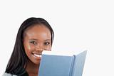 Side view of smiling woman reading a book