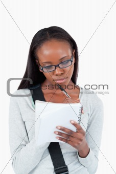 Young woman with glasses on taking notes