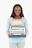 Smiling young woman with stack of books