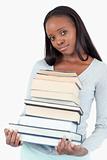 Sad smiling woman with pile of books