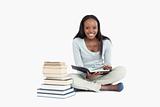 Smiling woman sitting next to a pile of books