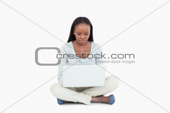 Young woman sitting on the floor with her laptop