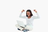 Young woman celebrating in front of her laptop