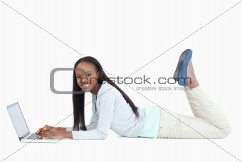 Side view of woman on the floor with her laptop