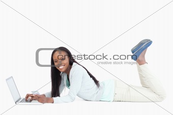 Side view of woman lying on the floor with her notebook