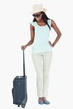 Smiling young woman looking at her suitcase