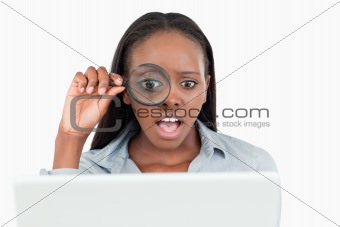 Businesswoman using a magnifying glass to look at her notebook