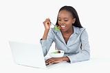 Businesswoman working with a laptop while eating a salad