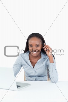Portrait of a businesswoman making a phone call while using a notebook