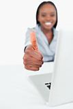 Portrait of a businesswoman using a laptop with the thumb up
