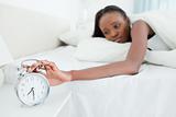 Woman switching off her alarm clock