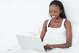 Smiling woman using a laptop before sleeping