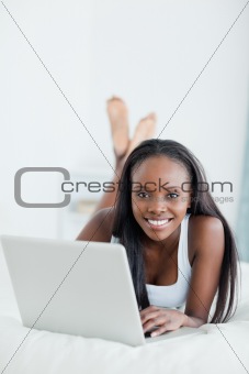 Portrait of a woman lying on her belly with a laptop