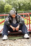 Young Man Sitting In Playground