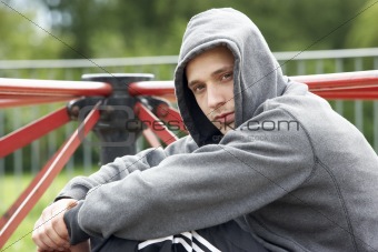 Young Man Sitting In Playground