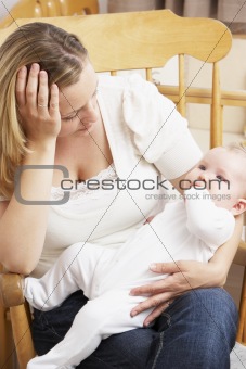 Worried Mother Holding Baby In Nursery