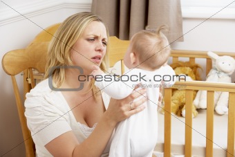 Stressed Mother Holding Baby In Nursery