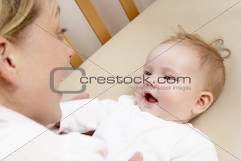 Mother Playing With Baby In Cot