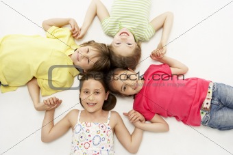 Circle of four young friends smiling and holding hands