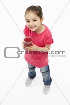 Studio Portrait of Smiling Girl Holding Glass of Juice