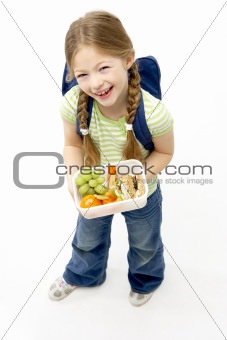 Studio Portrait of Smiling Girl Holding Lunchbox