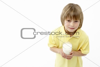 Studio Portrait of Smiling Boy Holding Glass of Milk