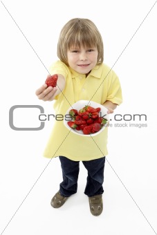 Studio Portrait of Smiling Boy Holding Bowl of Strawberries
