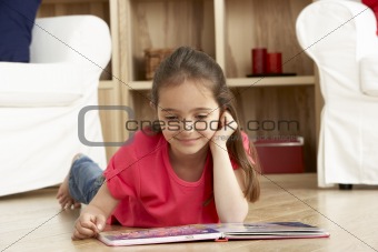 Young Girl Reading Book at Home
