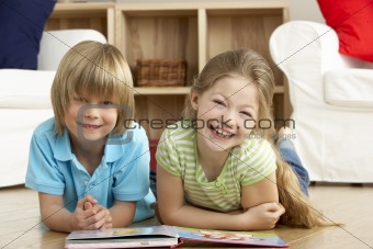 Two Young Children Reading Book at Home