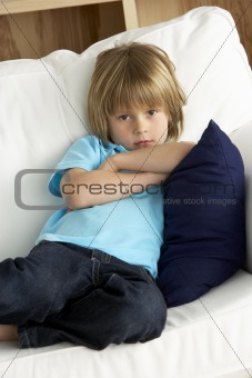 Young Boy Sat on Sofa at Home