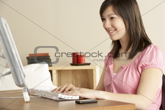 Smiling Teenage Girl on Computer at Home