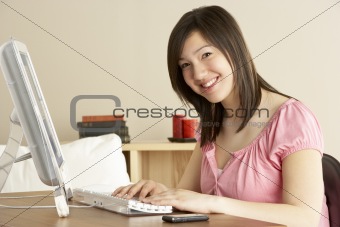 Smiling Teenage Girl on Computer at Home