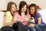 Teenage Girlfriends Reading Mobile Phone at Home