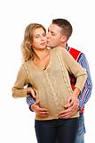 Young husband kissing his pregnant wife  on white background 
