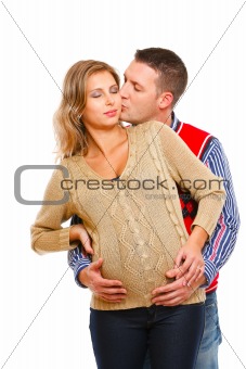 Young husband kissing his pregnant wife  on white background 
