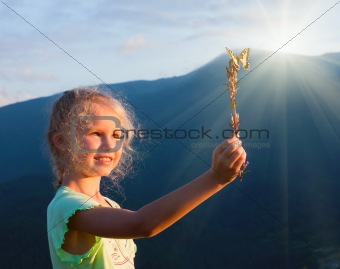 girl and butterfly in sunset mountain