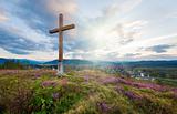Summer evening country view with wooden cross 