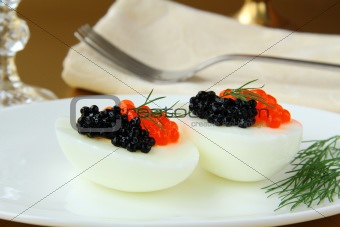 Boiled eggs with red and black caviar