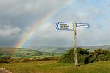 Rainbow over a signpost with destinations, UK.