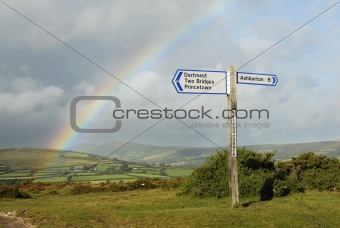 Rainbow over a signpost with destinations, UK.