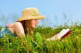 Young girl reading book in meadow