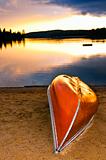 Lake sunset with canoe on beach