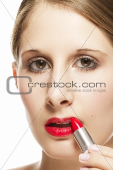 closeup of a beautiful woman applying lipstick