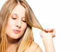 impishly blonde woman playing with her hairs