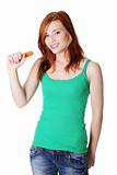 Teen standing girl holding a carrot.