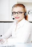 Caucasian woman in headset sitting behind the desk.