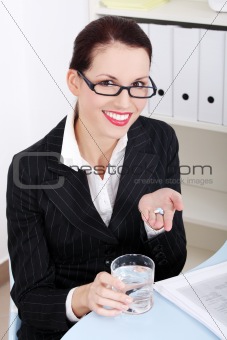 Businesswoman holding pills and water.