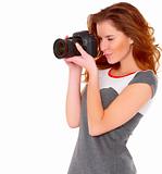 Woman in gray dress wit digtal camera on white