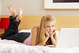 Teenage Girl Using Laptop In Bedroom