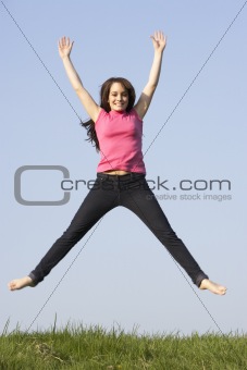 Teenage Girl Jumping In Summer Meadow